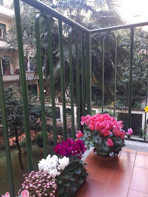 two vases filled with flowers sitting on a balcony at Appartamento Diego in Milan