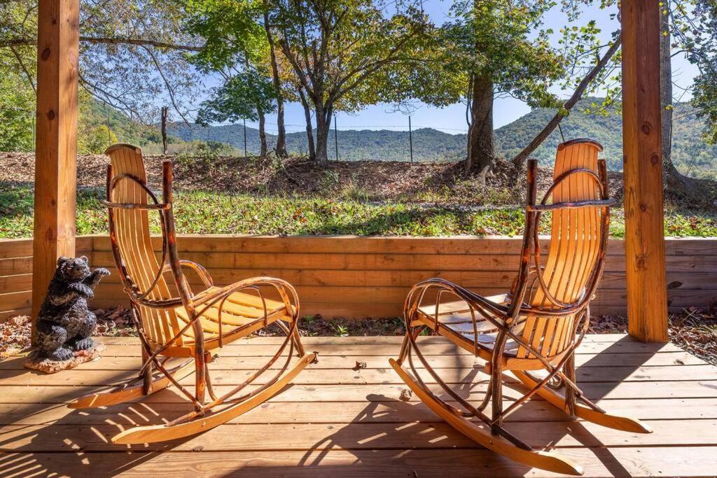 two rocking chairs on a porch with a teddy bear at *NEW* Cozy mountain view cabin close to lake and hiking in Robbinsville