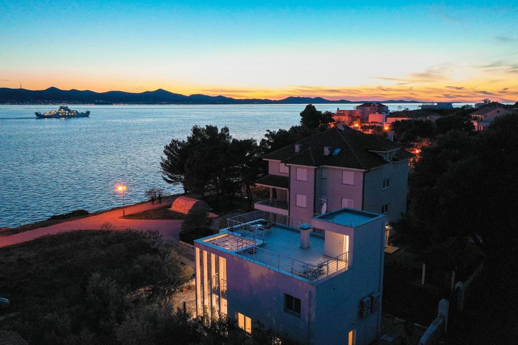 a building on the shore of a body of water at Karma 52 in Zadar