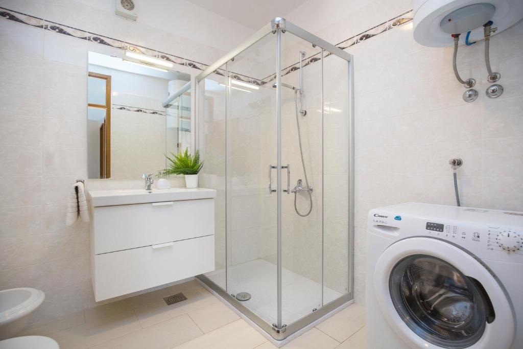 łazienka z prysznicem i pralką w obiekcie Ripenda Apartments w mieście Labin