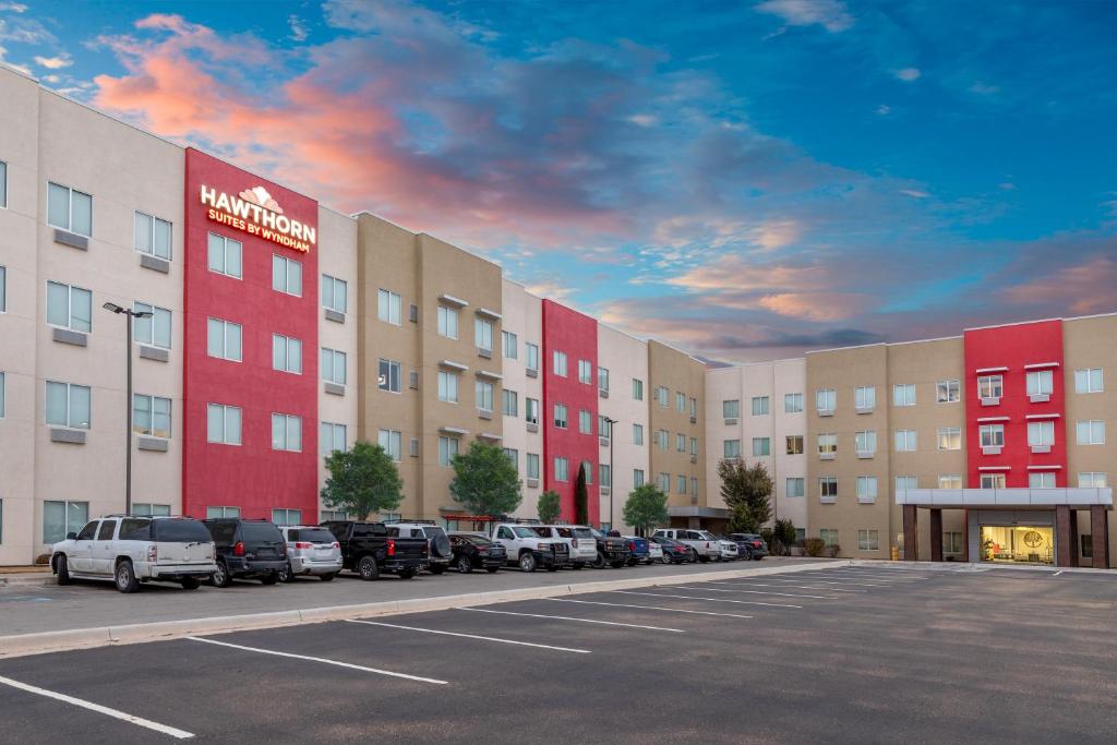 un estacionamiento con autos estacionados frente a un edificio en Hawthorn Suites by Wyndham Lubbock en Lubbock