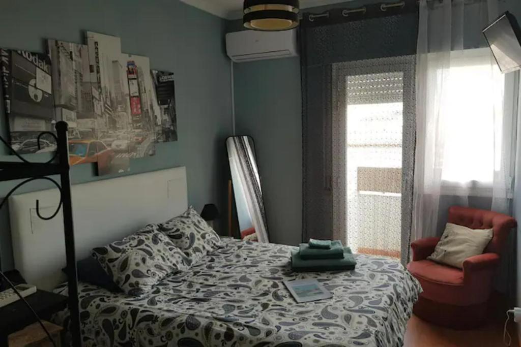 um quarto com uma cama, uma cadeira e uma janela em AL - Comfortable House em Faro