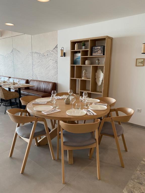 a dining room with a wooden table and chairs at Hôtel L'Albatros in Saint-Trojan-les-Bains