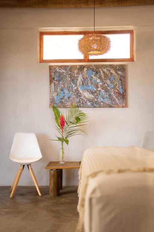 a bedroom with a bed and a table with a vase of flowers at Casa Coraje in Palomino