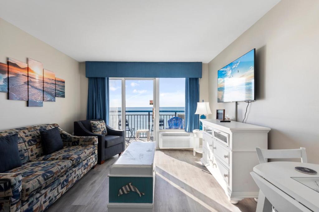 ein Wohnzimmer mit einem Sofa und einem TV in der Unterkunft 11-th Floor OcenView w Balcony cozy condo at Boardwalk Resort in Myrtle Beach