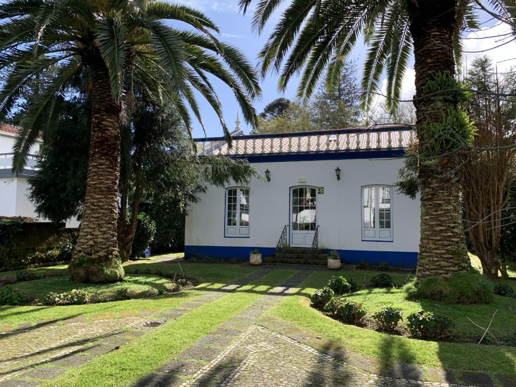 una casa blanca con palmeras delante en Casa Delft en Furnas