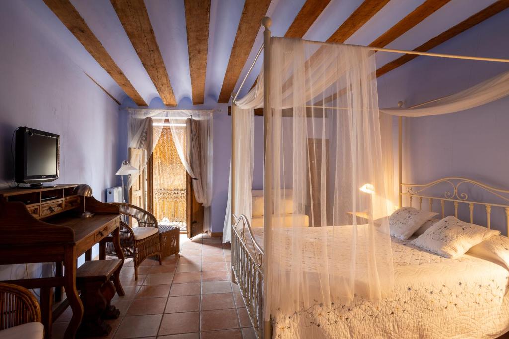 a bedroom with a canopy bed and a piano at La Casa Grande in Talayuelas
