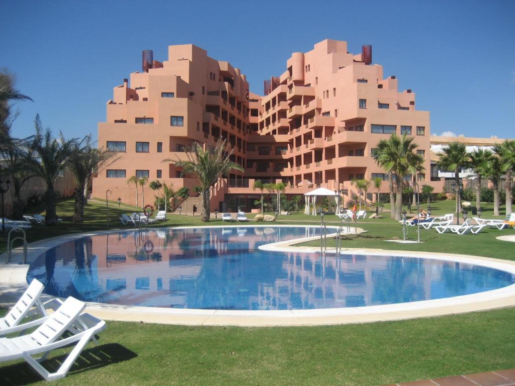 a large swimming pool in front of a resort at Don Juan Beach Resort in Estepona