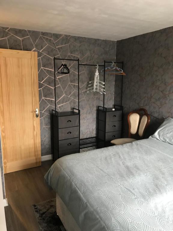 a bedroom with a bed and two dressers at Double Room next to Burnham Elizabeth Line Station in Slough
