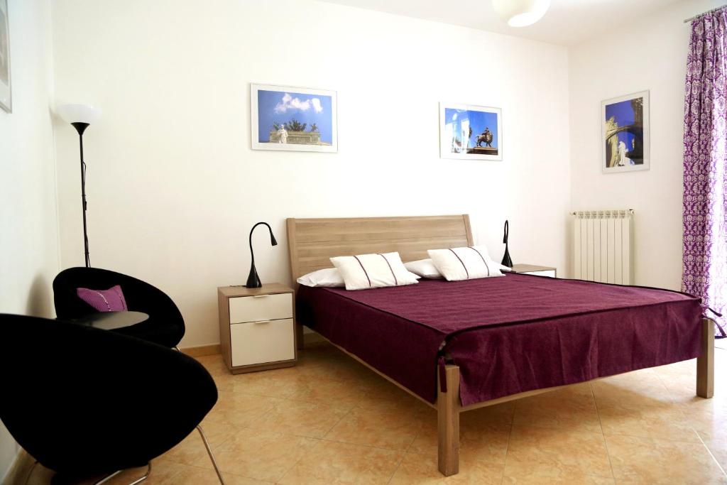 ein Schlafzimmer mit einem Bett und einem Stuhl in der Unterkunft B&B Siciliò in Santa Flavia