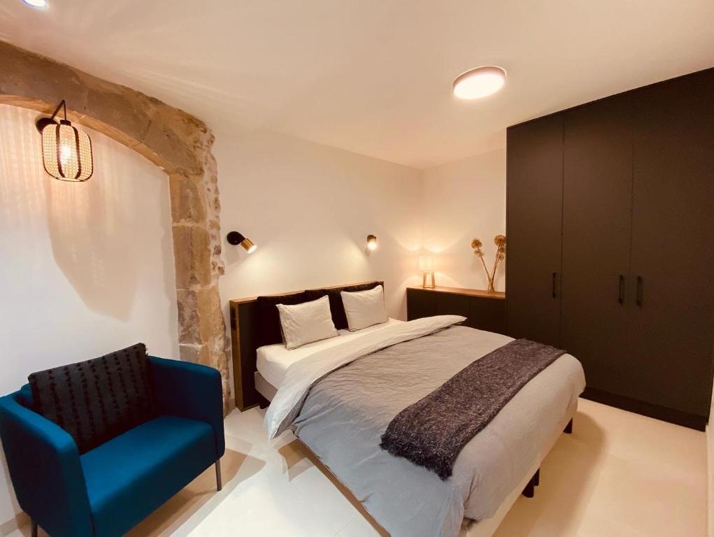 um quarto com uma cama e uma cadeira azul em Appartement confortable et moderne em La Roche-sur-Foron