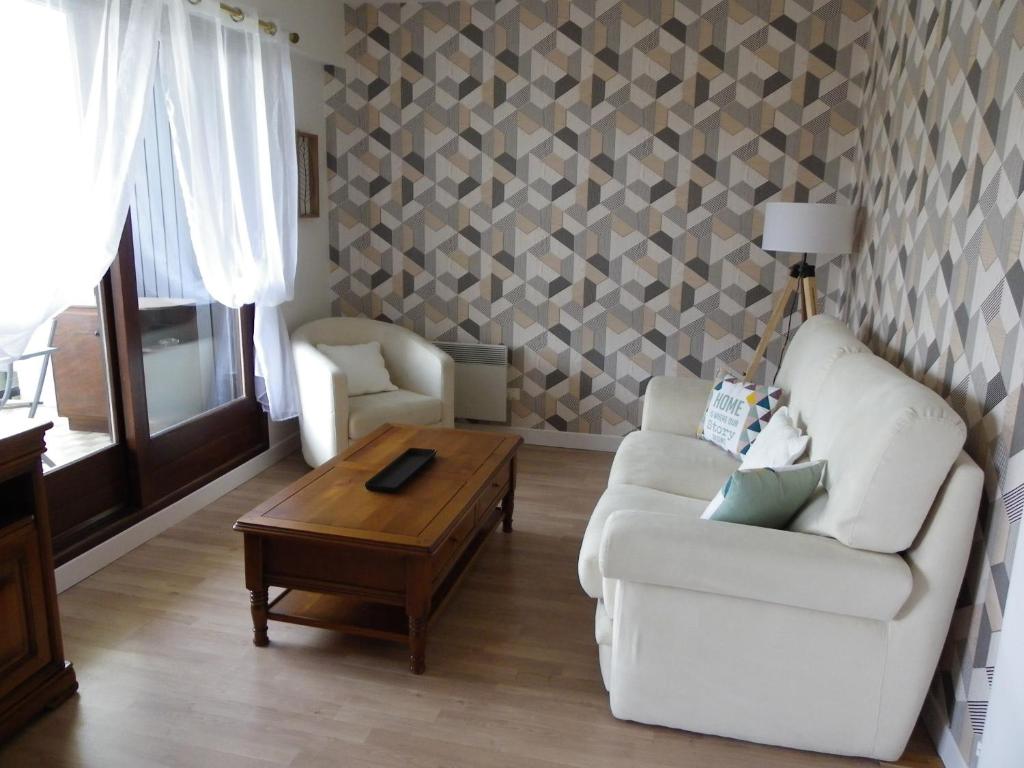 uma sala de estar com um sofá e uma mesa de centro em f2 gerardmer em Gérardmer