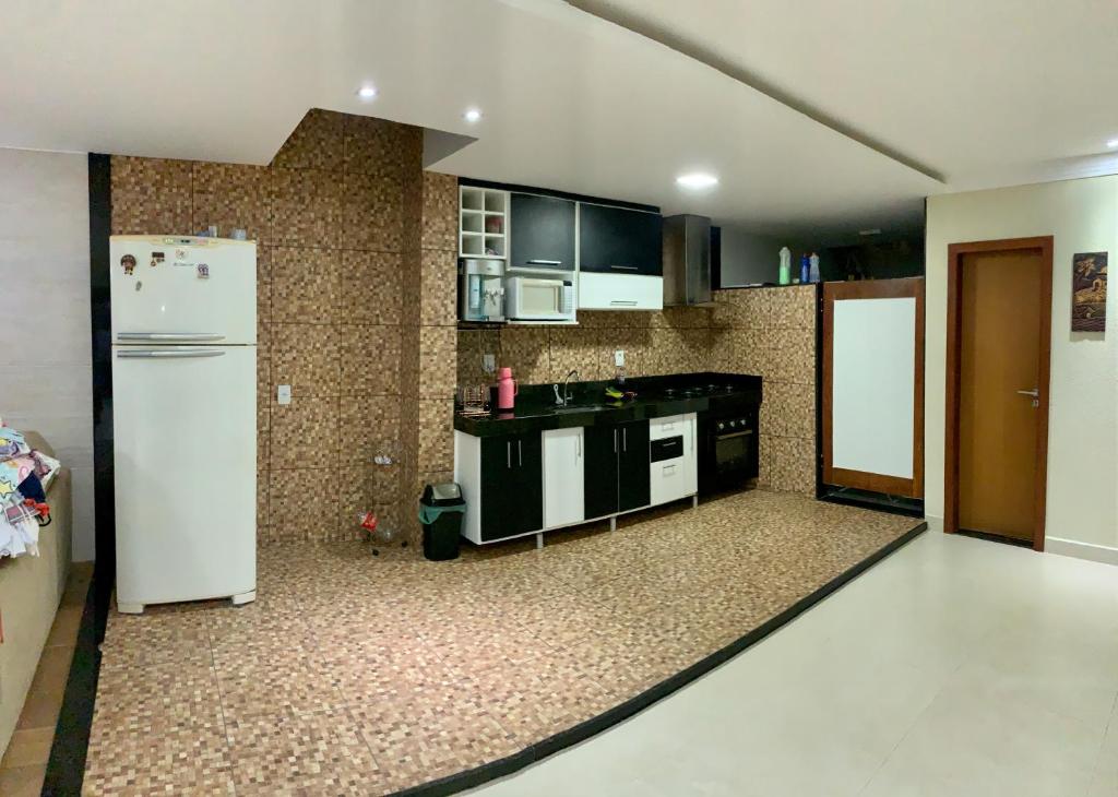 - une cuisine avec des appareils en noir et blanc et un réfrigérateur blanc dans l'établissement Casa temporada com piscina, à Vila Velha