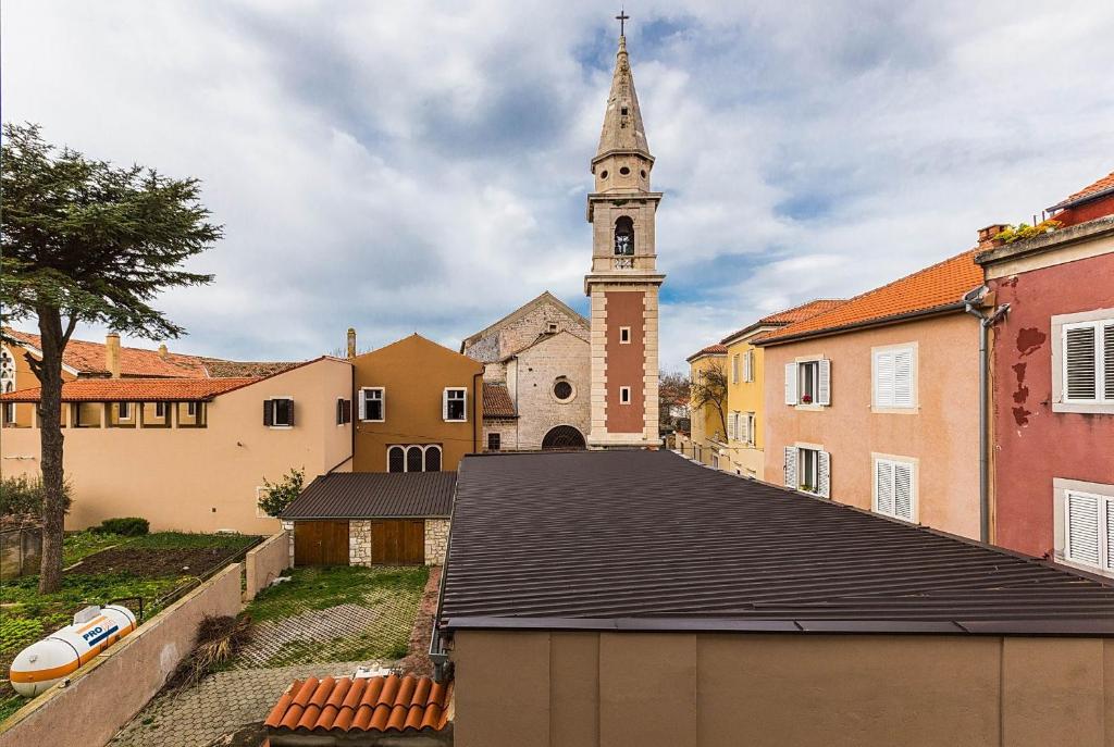 una iglesia con una torre de reloj en una ciudad en Forum 2BR apartment in old town, en Zadar