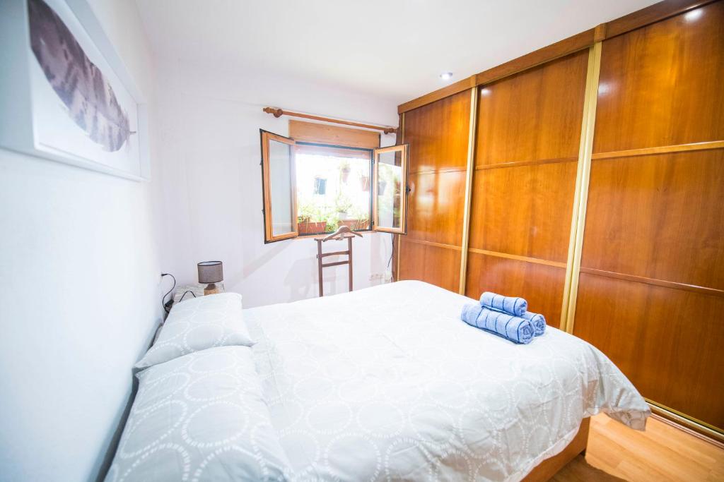 1 dormitorio con cama blanca y armarios de madera en Placeta San Nicolas, en Granada