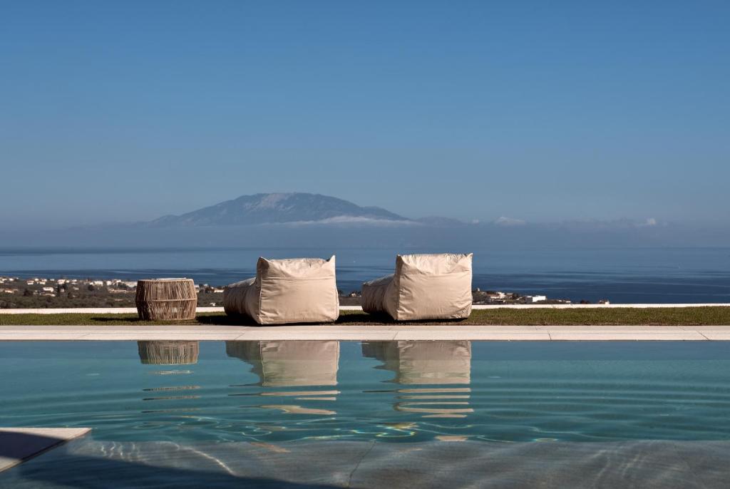 un gruppo di sedie sedute accanto a una piscina di Julieta Villas a Città di Zante