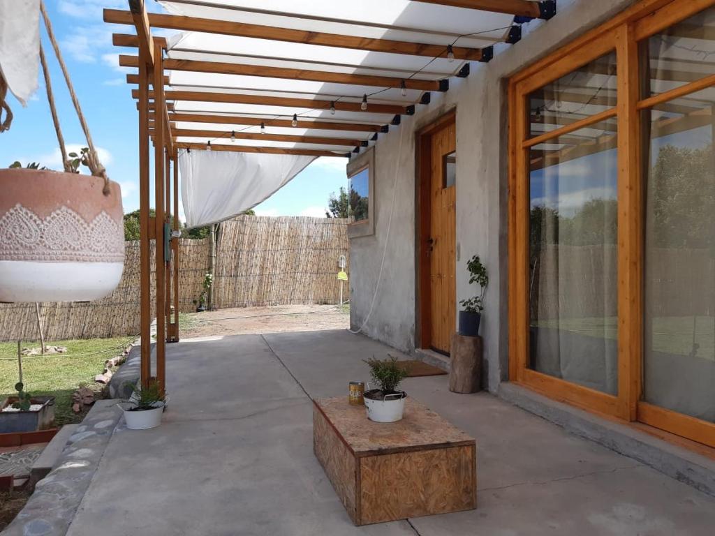 a patio with a wooden pergola and a table at El Nevado Casa de Campo in San Rafael