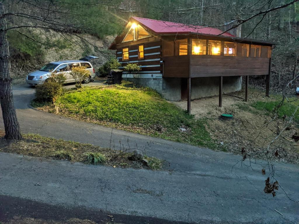 a house on a hill with a car parked next to it at The Robins Nest with hot tub in Pigeon Forge