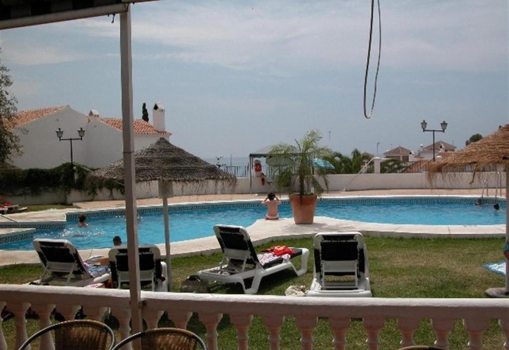 een zwembad met ligstoelen en een zwembad bij Casa Galesa in Nerja