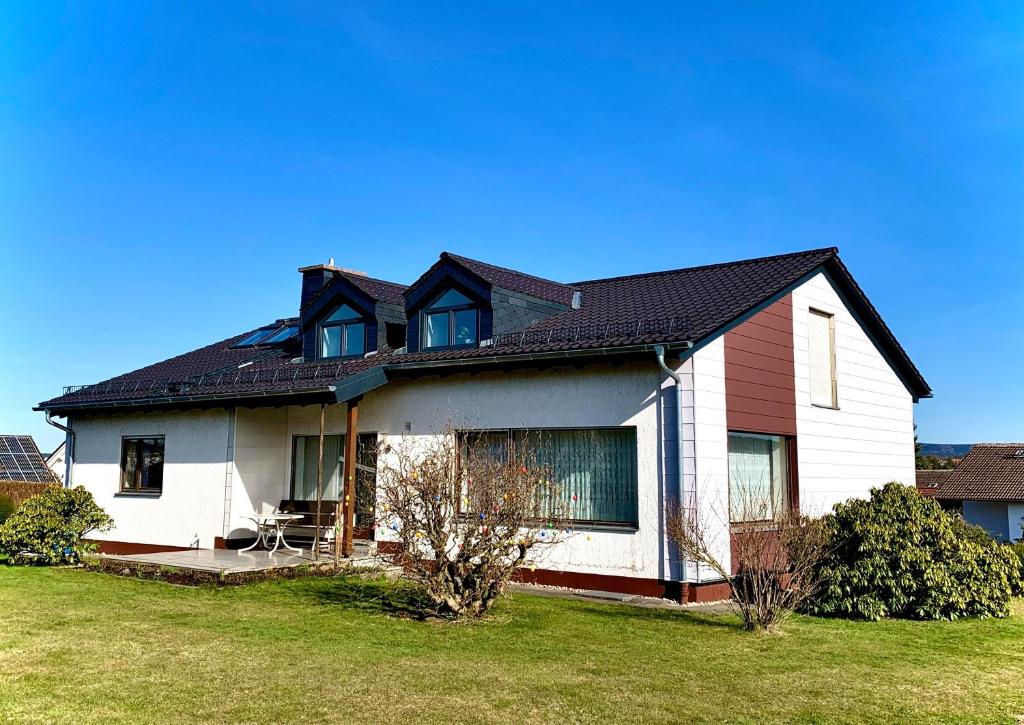 a white house with a black roof at Ferienwohnung Waldhütter in Schwarzenbach an der Saale