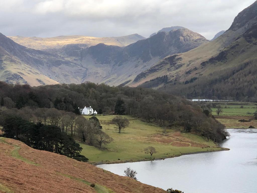 a view of a river with mountains in the background at Wood House Cottage in Cockermouth