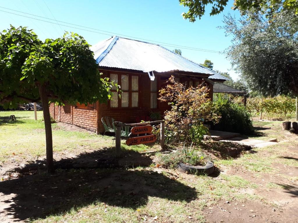 una pequeña casa de ladrillo con un árbol delante de ella en Cabaña: LOS ABUELOS, en San Rafael