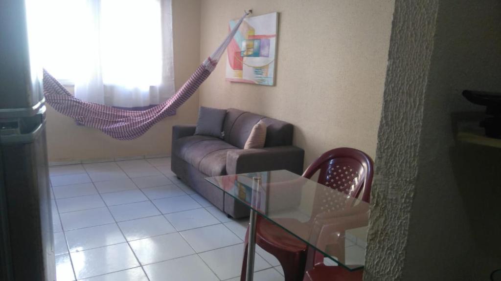 a living room with a couch and a hammock at Apartamento Caucaia-CE, próximo á praia de Cumbuco in Fortaleza