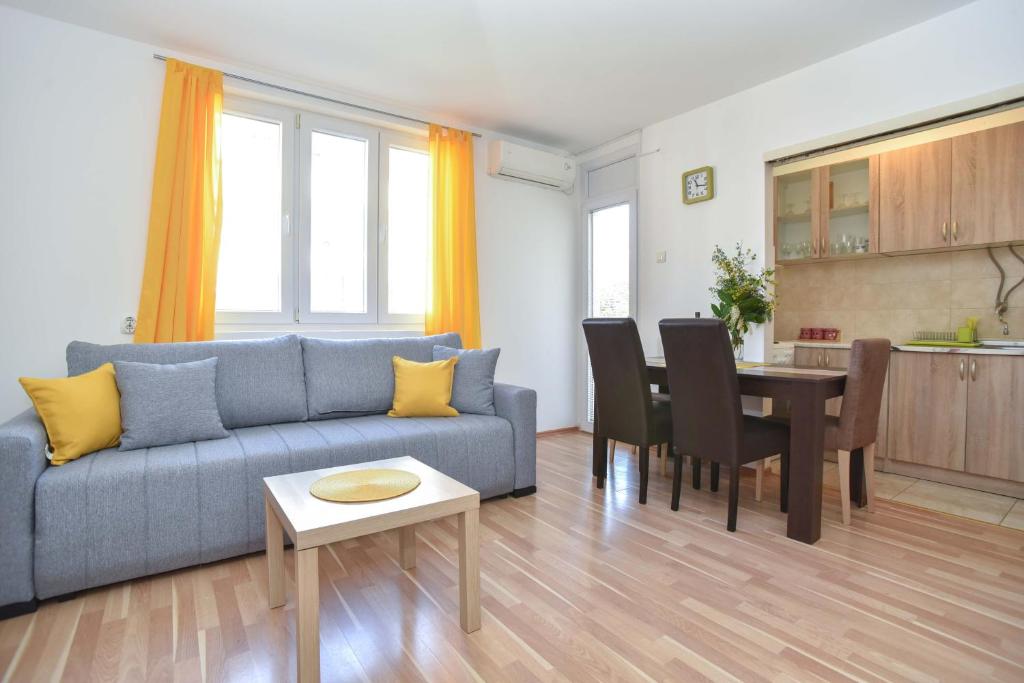 een woonkamer met een blauwe bank en een tafel bij Apartment near Old Town in Budva
