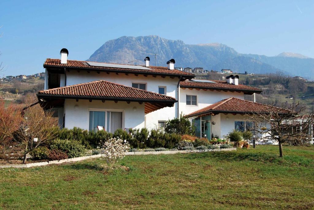 una casa blanca con una montaña en el fondo en casa Rosalba, en Strigno