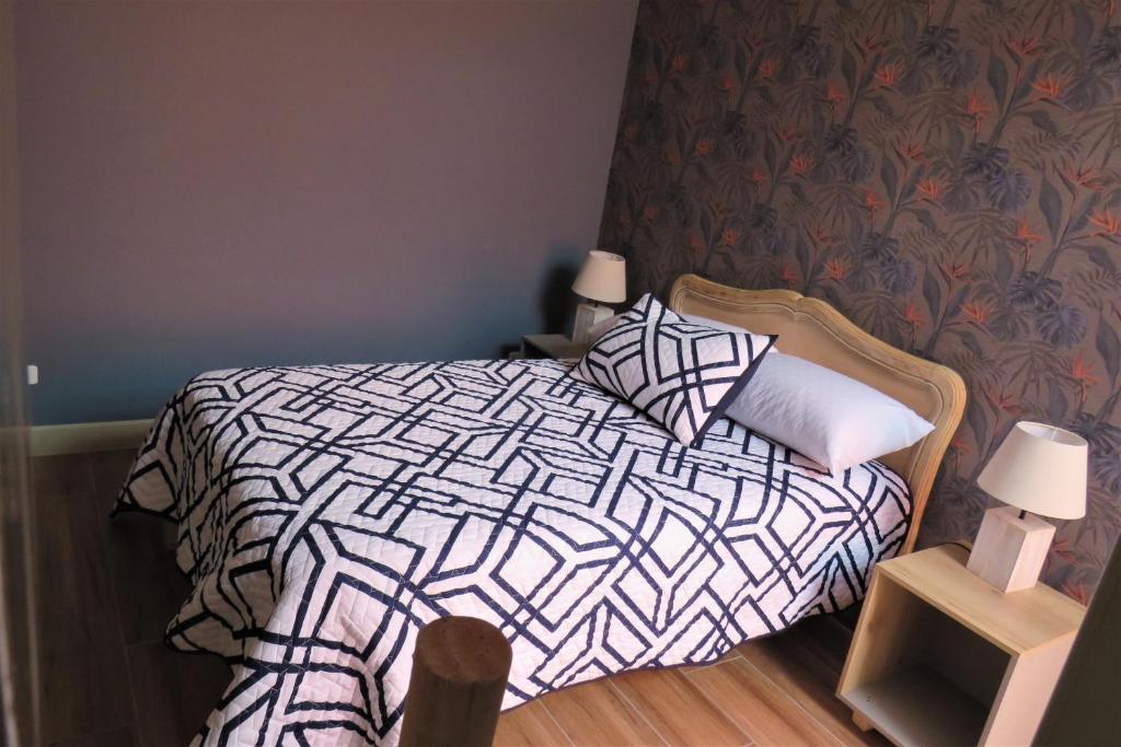 a bedroom with a bed with a black and white comforter at TEYFA Hospedaje - Departamento in Atuntaqui