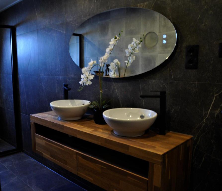 een badkamer met 2 wastafels op een houten aanrecht met een spiegel bij Huis nummer 7 met sauna en 3 slaapkamers in Leeuwarden