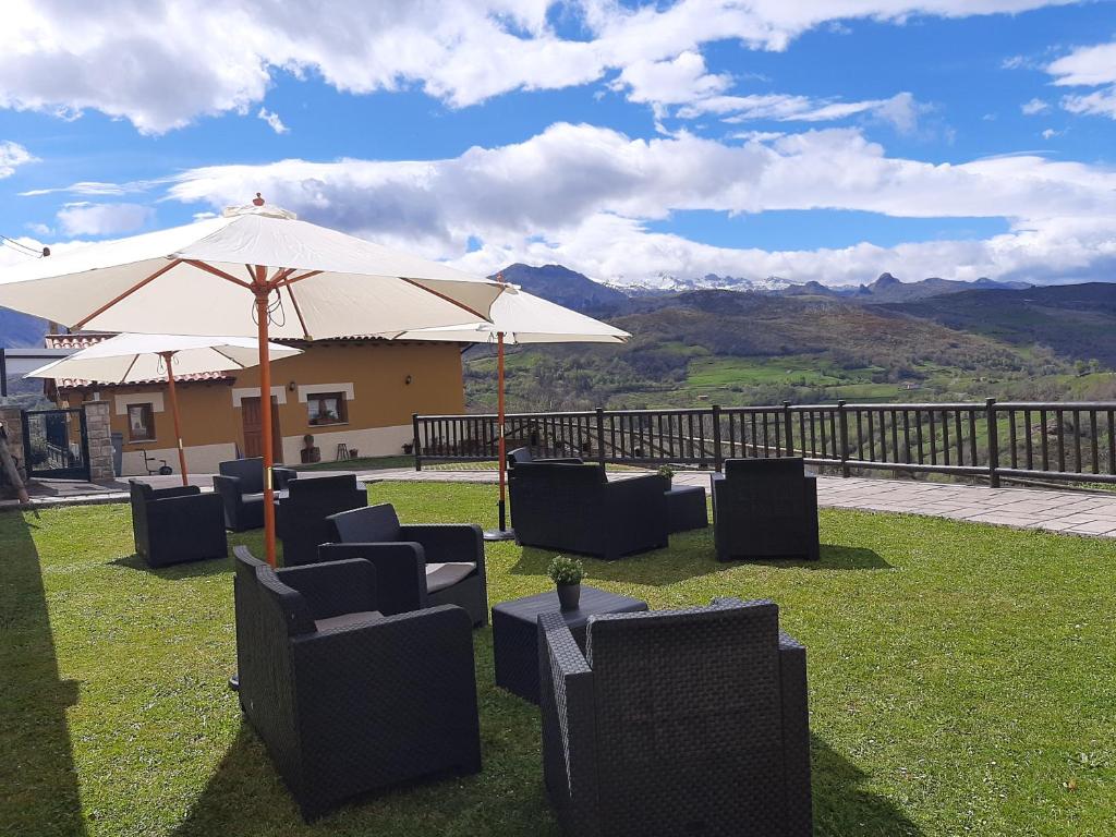 a group of chairs and an umbrella on the grass at Valle la Fuente in El Escobal