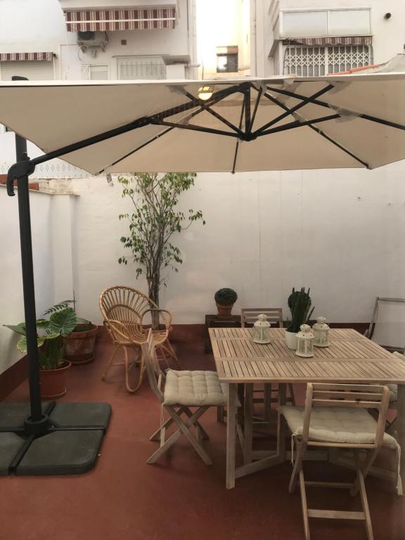 einen Tisch, Stühle und einen Regenschirm in einem Zimmer in der Unterkunft 2 Apartamento TERRAZA Free Wifi in Valencia