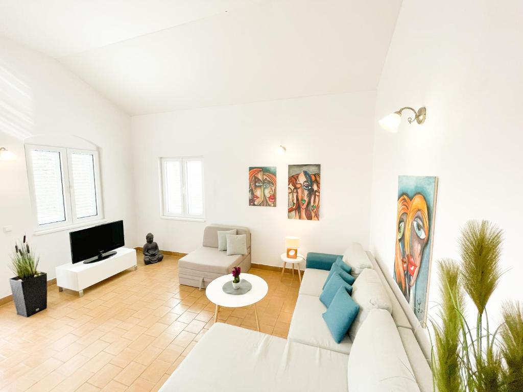 Biały salon z kanapą i telewizorem w obiekcie Spacious Apartment Amaros w Korčuli