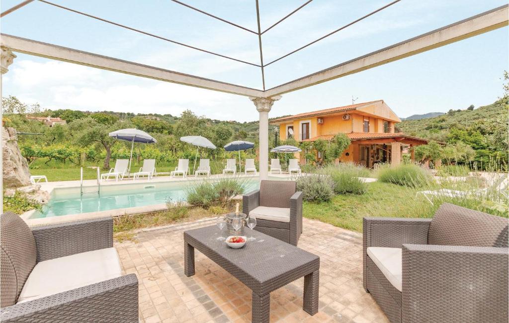 an outdoor patio with a table and chairs and a pool at Villa Altea in Itri