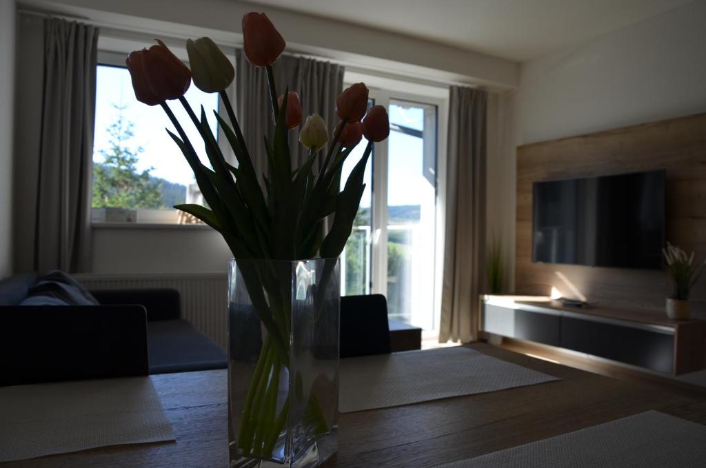 eine Vase von Tulpen auf einem Tisch im Wohnzimmer in der Unterkunft Visit Klinovec in Loučná pod Klínovcem