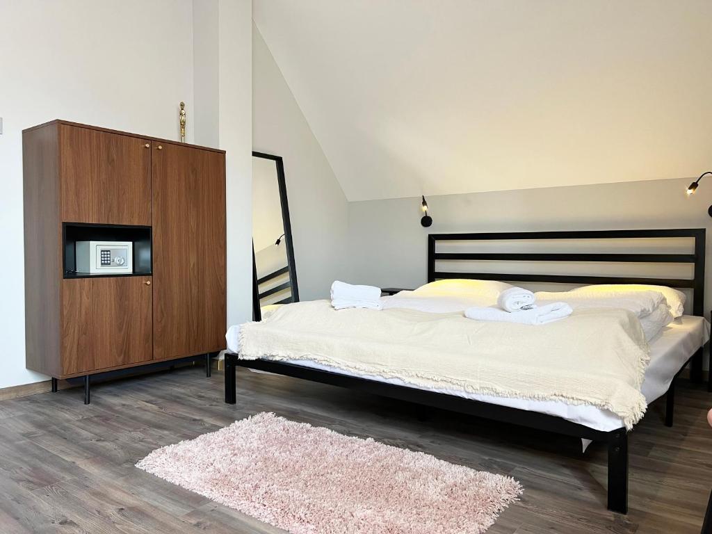 - une chambre avec un grand lit et une armoire en bois dans l'établissement Nussbaum Panzió, à Keszthely