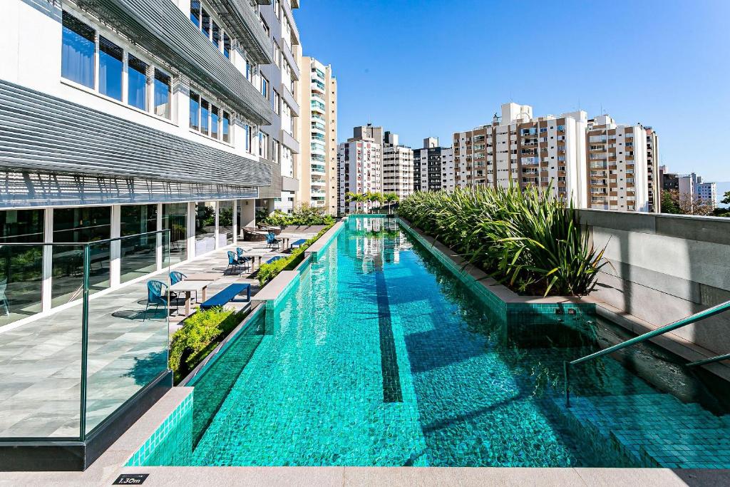 a swimming pool on the side of a building at Gym | Food Hall | 450m from the mall #CA04 in Florianópolis