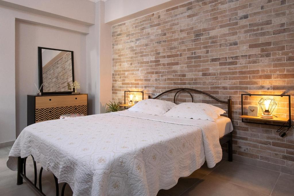 a bedroom with a bed and a brick wall at Silvia's Apartments in Corfu Town