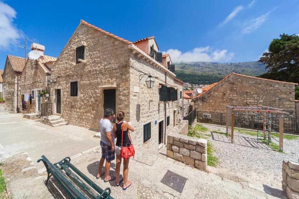 um grupo de pessoas a olhar para um antigo edifício de pedra em Apartments Vi-La em Dubrovnik