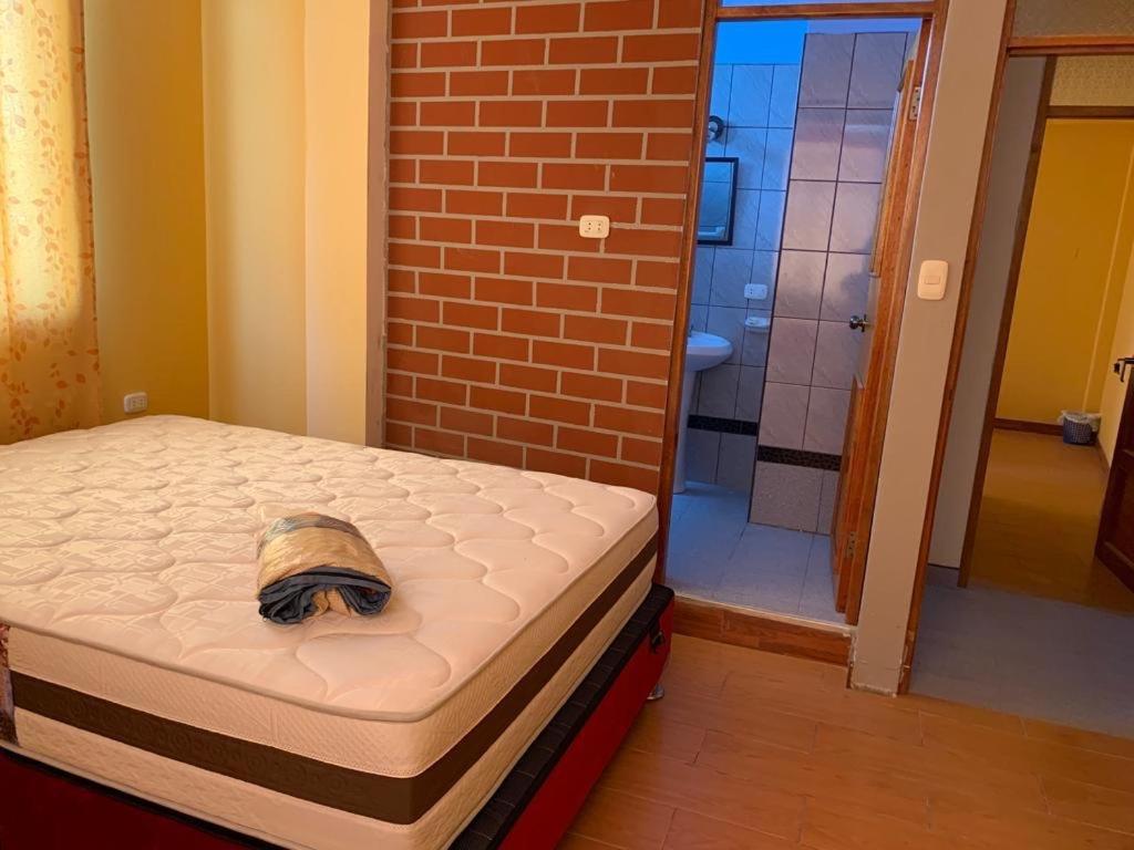 une paire de matelas dans une chambre avec un mur en briques dans l'établissement Alojamiento en Mancora - Alipio House, à Máncora