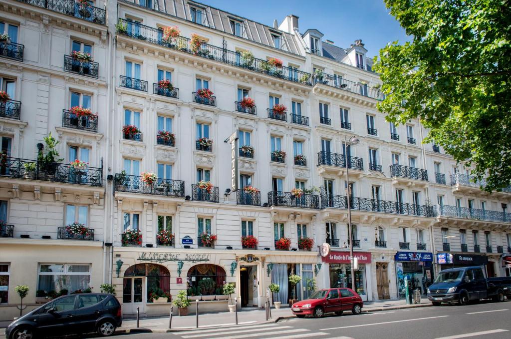 un gran edificio blanco en una calle con coches aparcados delante en Hotel Minerve, en París