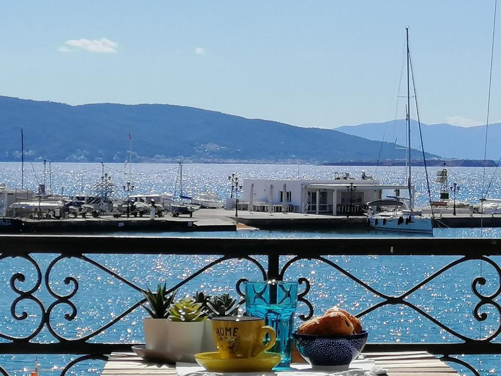 uma vista para uma marina com uma mesa com comida numa varanda em Aegina Port Apt 3 em Egina