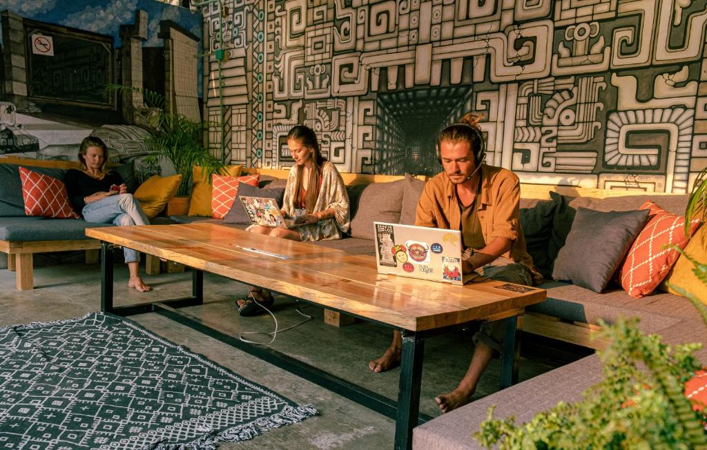 a group of people sitting around a table with a laptop at 13 Cielos Hostel in San Cristóbal de Las Casas