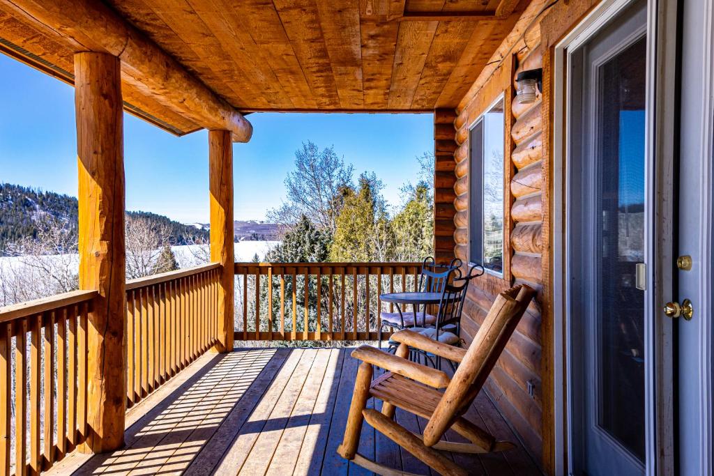 a porch with two rocking chairs on a cabin at Half Moon Lake Lodge in Pinedale