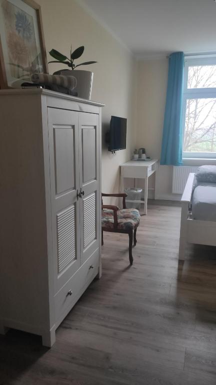 ein Schlafzimmer mit einem weißen Schrank und einem Bett in der Unterkunft Herrenhaus Schmölen in Bennewitz