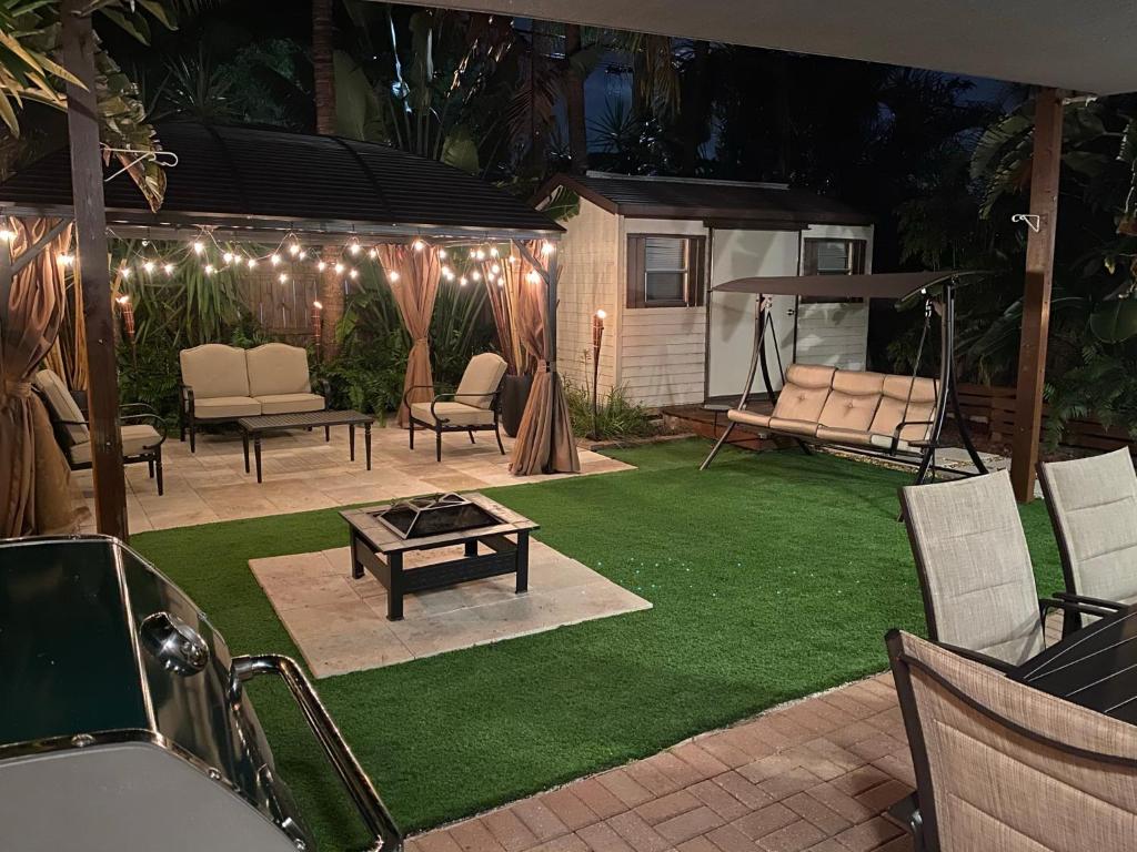 a backyard with a lawn with chairs and a table at Cozy House in Fort Lauderdale