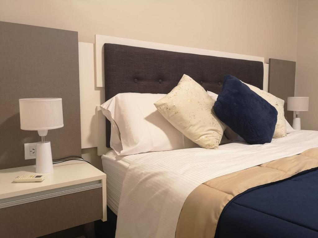 Un dormitorio con una cama con almohadas. en Precioso Departamento - Excelente ubicación en Mendoza