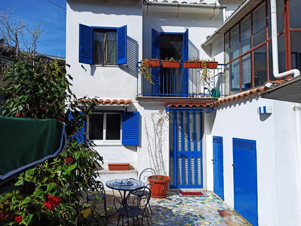 a white building with blue doors and a table at Casa Vacanze Smeralda Amalfi Coast in Vietri sul Mare