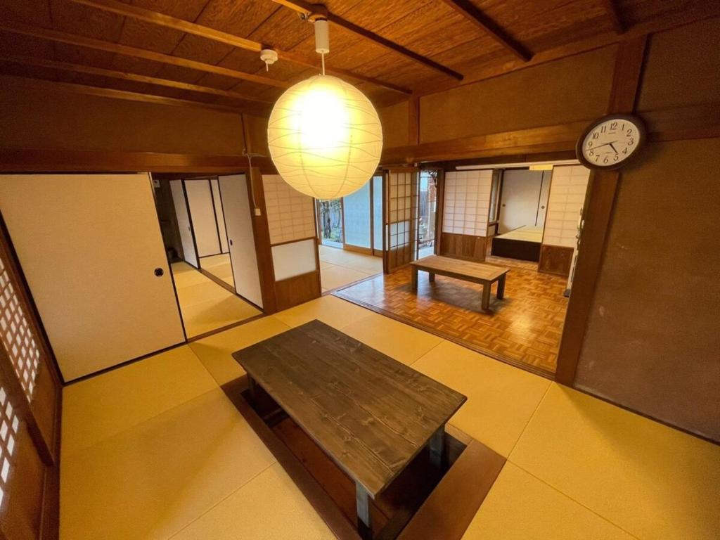 une chambre avec une table et une horloge sur le mur dans l'établissement Shozu no Yado Hamakaze - Vacation STAY 37514v, à Ōbe